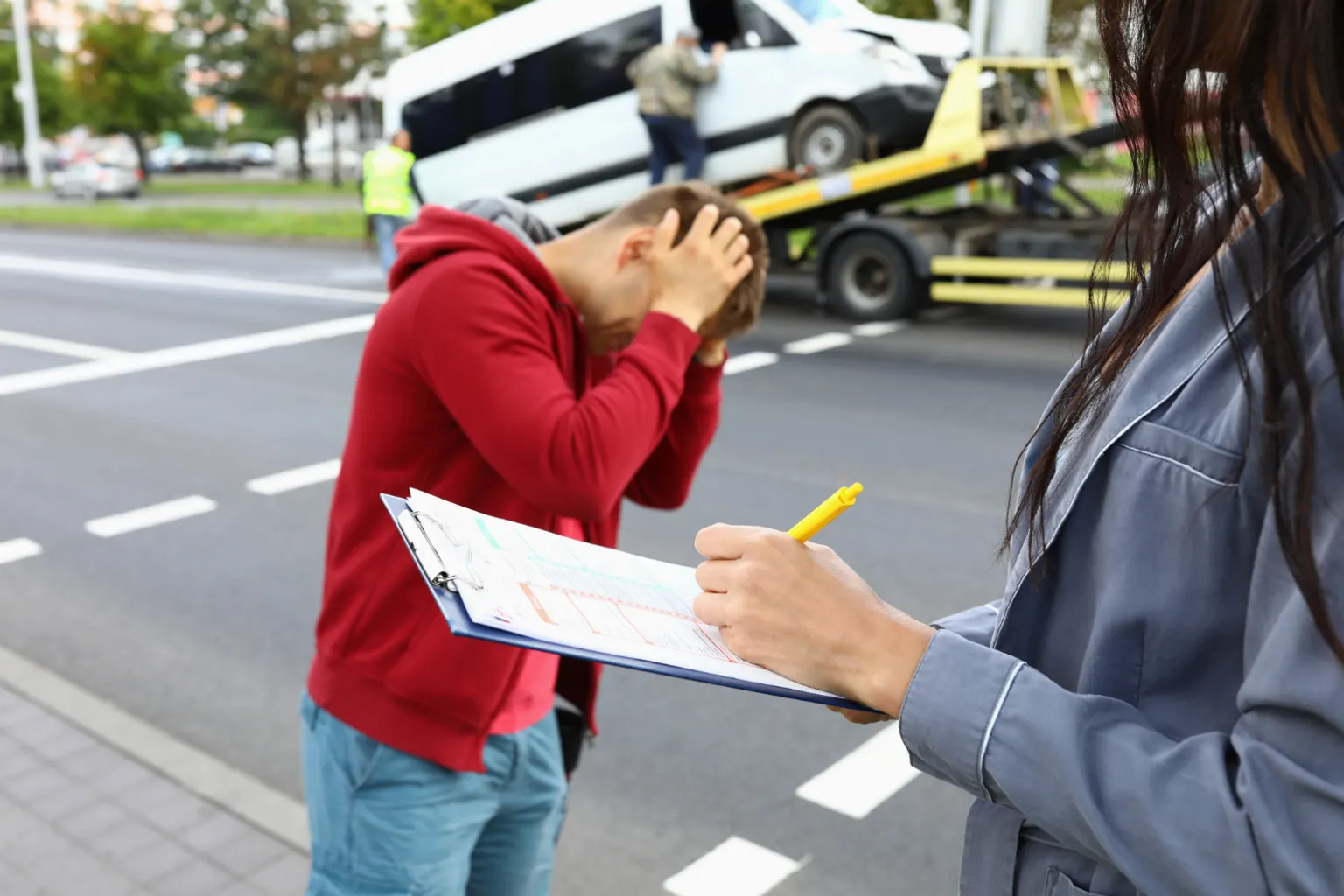 Gestionnaire de flotte examinant les contrats d’assurance de plusieurs véhicules d’entreprise stationnés.