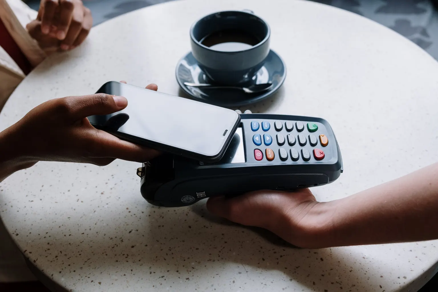 Une commerçante utilise une caisse tactile sans fil sur un comptoir de magasin.