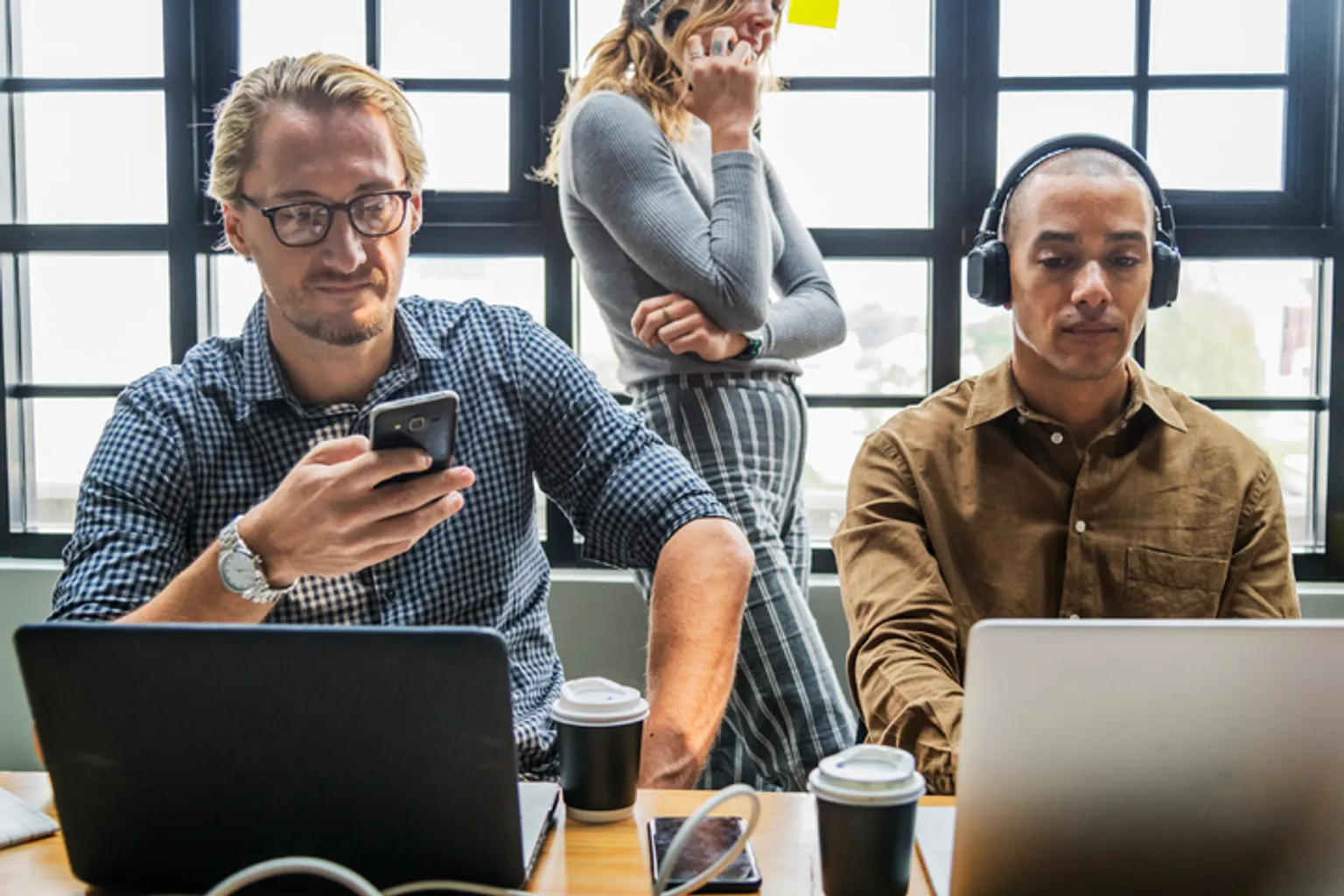 Espace de coworking lumineux avec bureaux partagés, salles de réunion et entrepreneurs au travail.