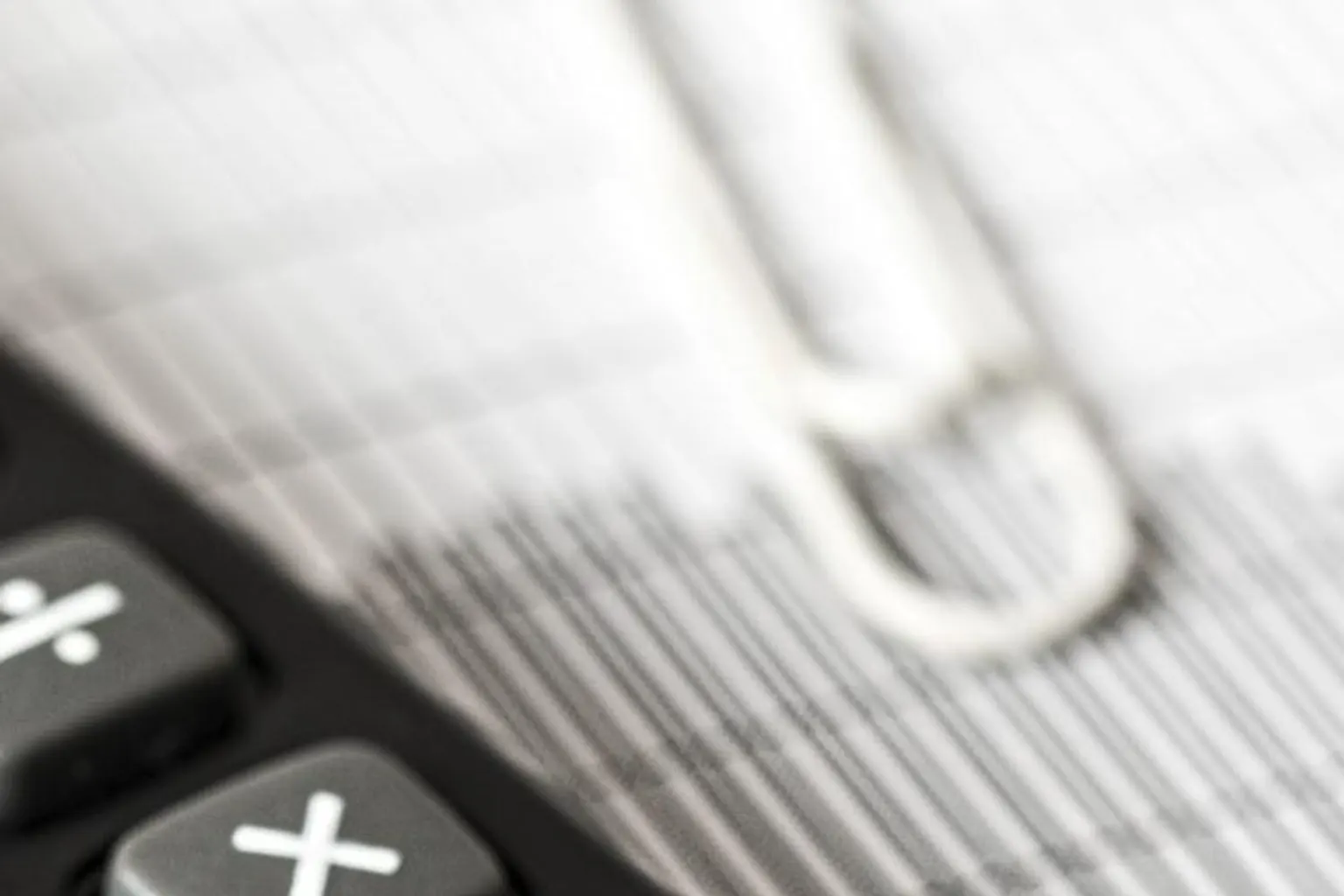 Dirigeante de petite entreprise analysant un plan de trésorerie et des factures sur son bureau.