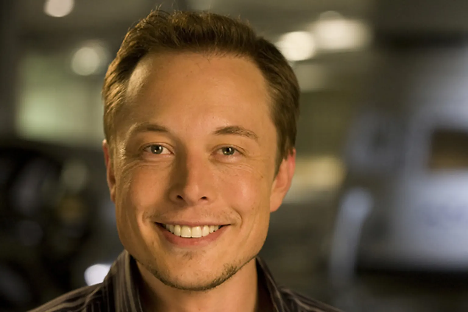 Elon Musk devant un véhicule électrique Tesla, illustration de la rémunération des grands dirigeants américains.