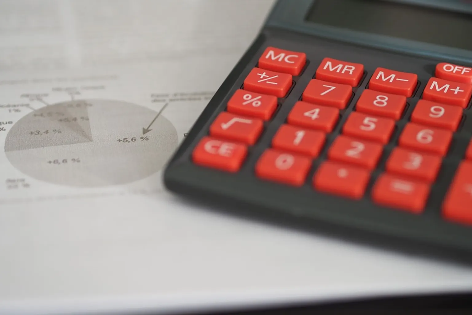 Un dirigeant échange avec son expert-comptable devant des tableaux de bord financiers dans un bureau.