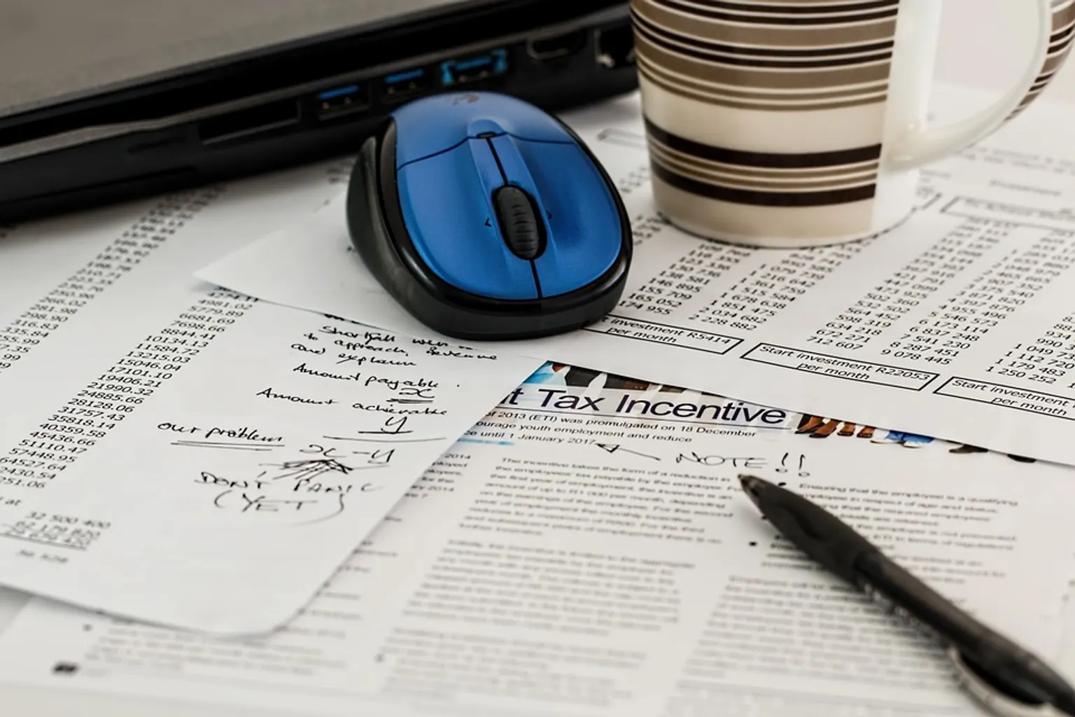 Calculatrice, documents fiscaux et graphiques illustrant les réformes de l’impôt sur les sociétés et de l’impôt sur le revenu.