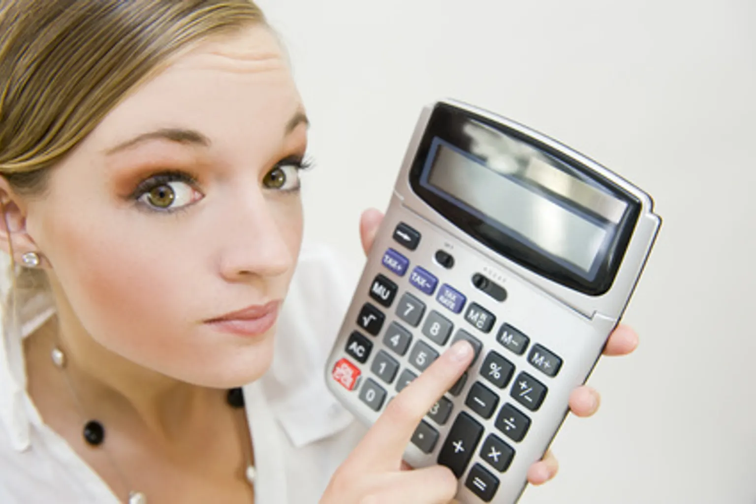 Dirigeante analysant des documents comptables et un tableau de bord financier sur son ordinateur.