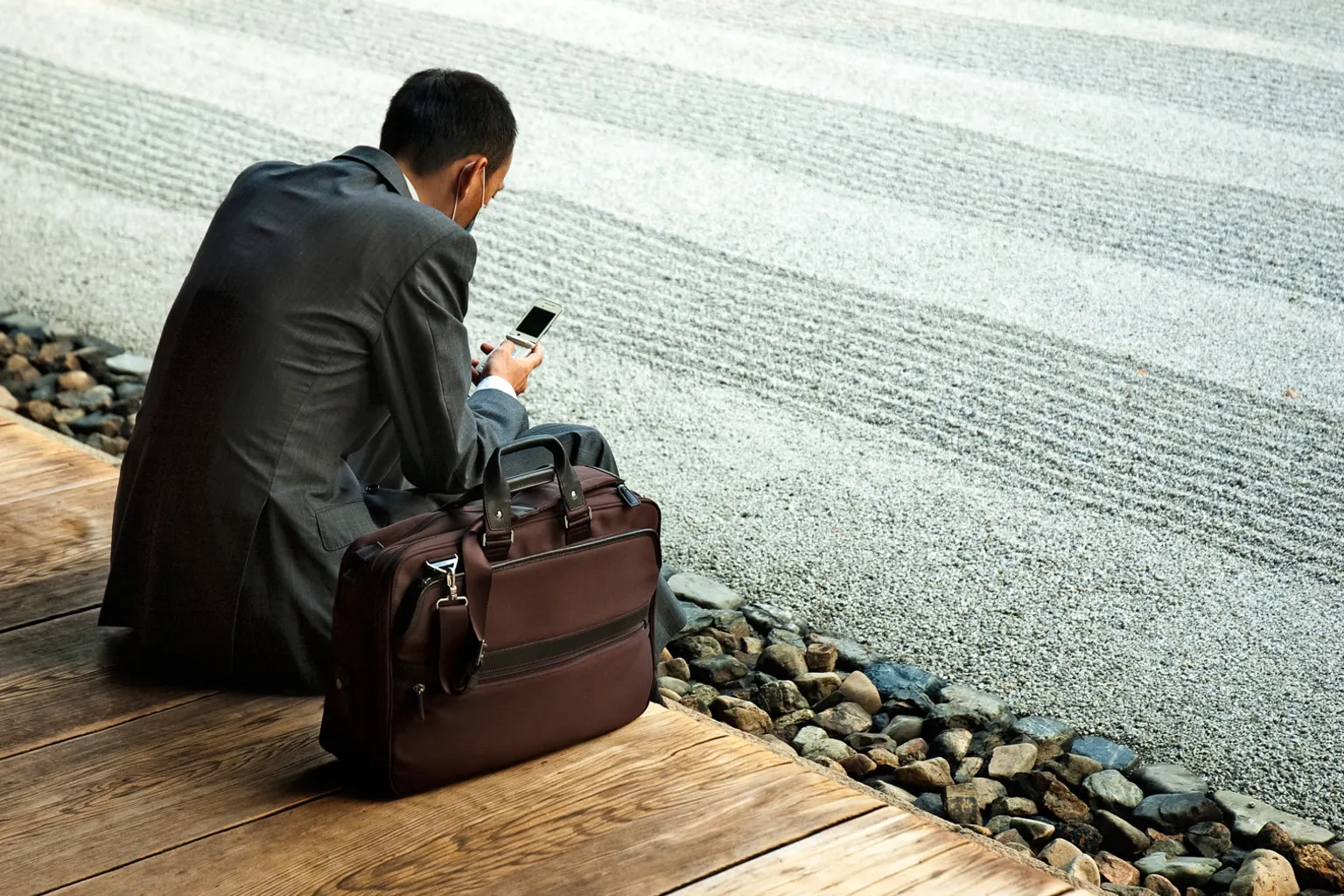 Entrepreneur travaillant sur un carnet de notes et un ordinateur dans un espace de travail lumineux.