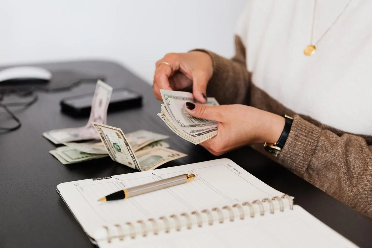Dirigeante analysant un bilan comptable et des indicateurs financiers sur son bureau.