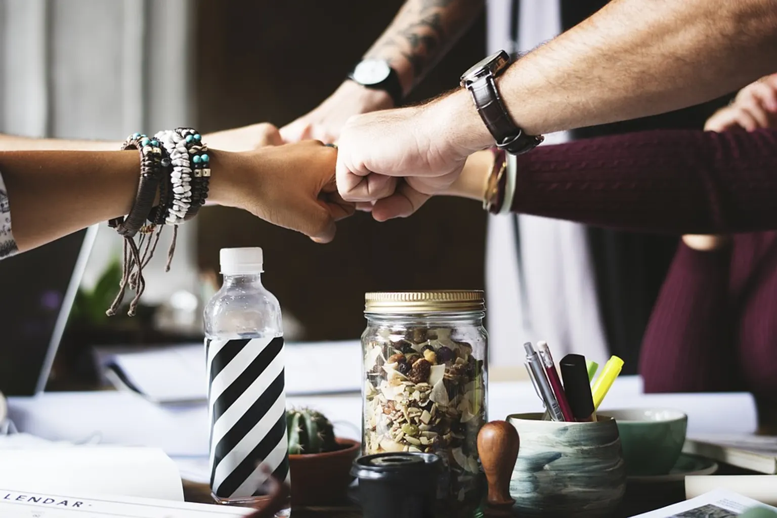 Réunion entre un responsable achats et ses équipes devant un tableau de bord de suivi des fournisseurs et des coûts.