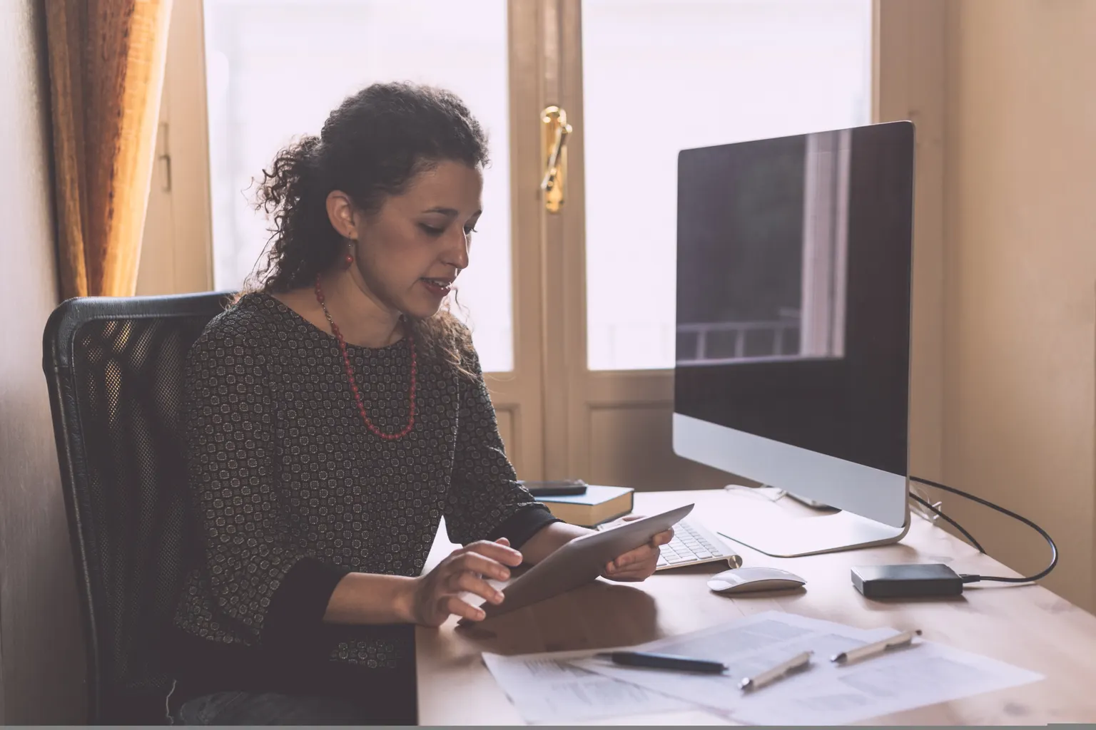 Entrepreneure préparant un dossier de financement pour lancer son entreprise avec son conseiller bancaire.