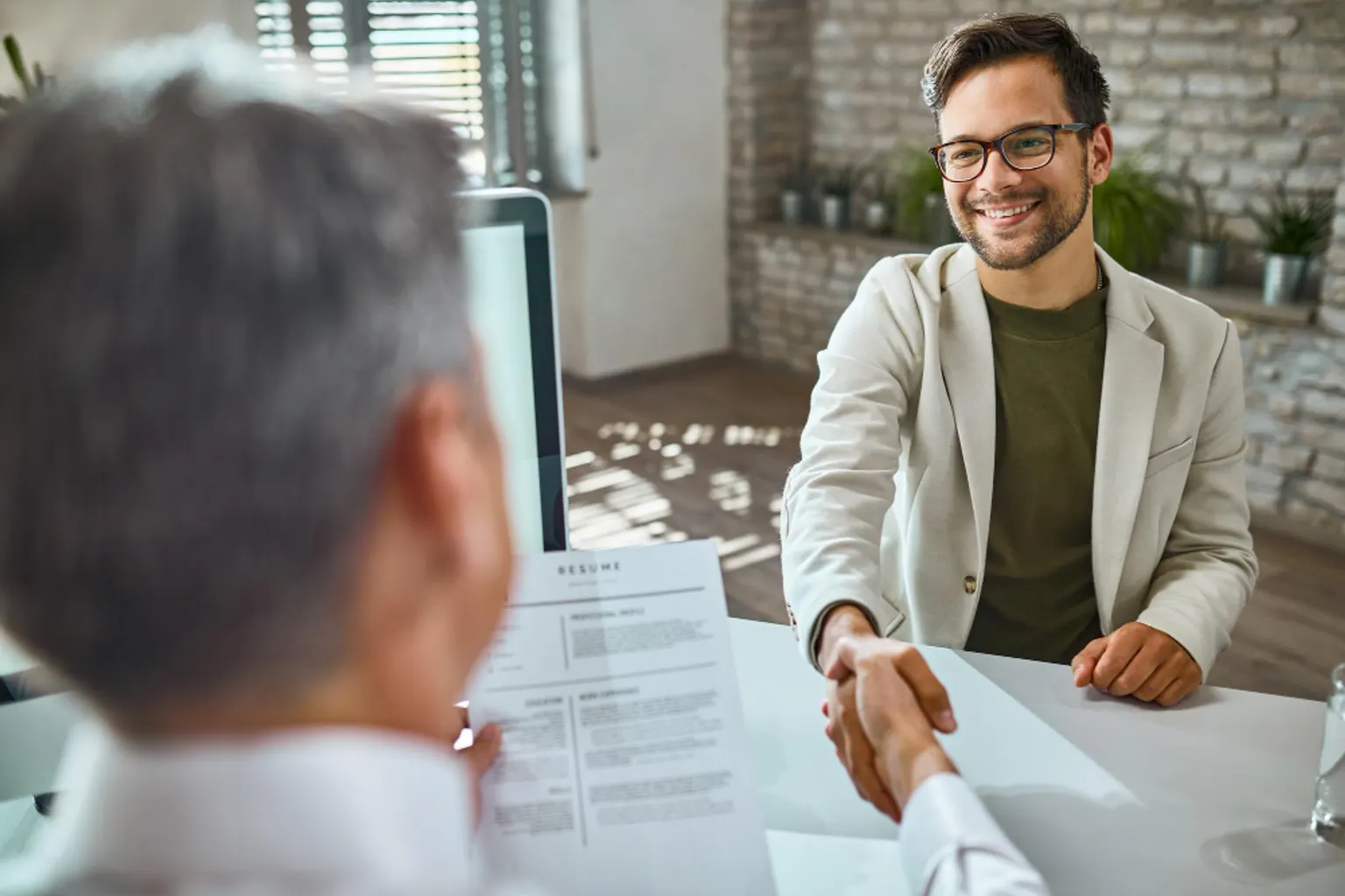 Une candidate consulte des offres d’emploi et organise ses candidatures sur son smartphone et son ordinateur.