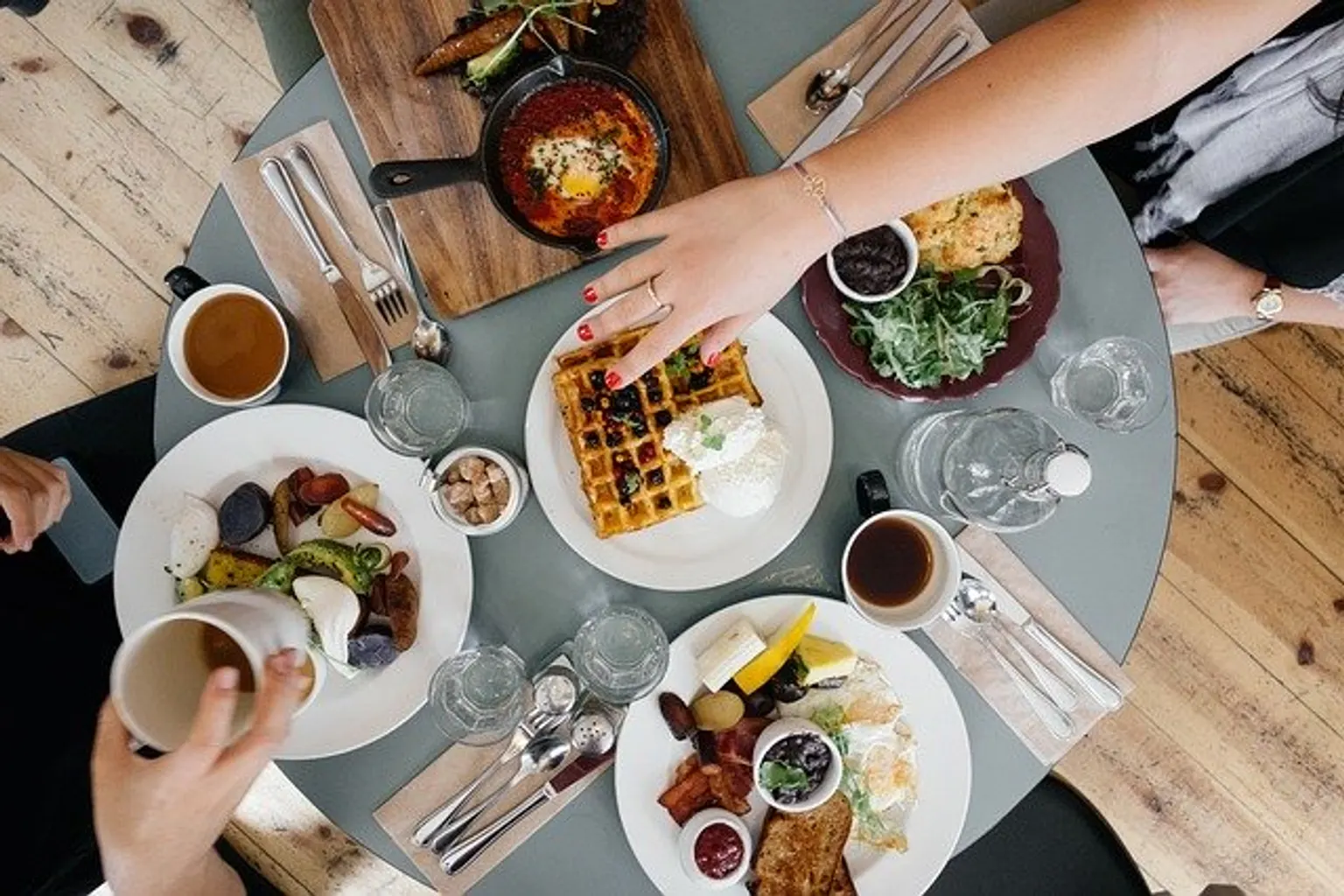 Collaborateurs réunis autour d’une table de petit déjeuner avant une réunion matinale au bureau.