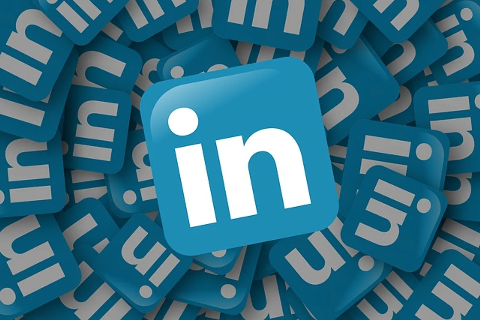 Dirigeante consultant la page LinkedIn de son entreprise sur un ordinateur dans un bureau.