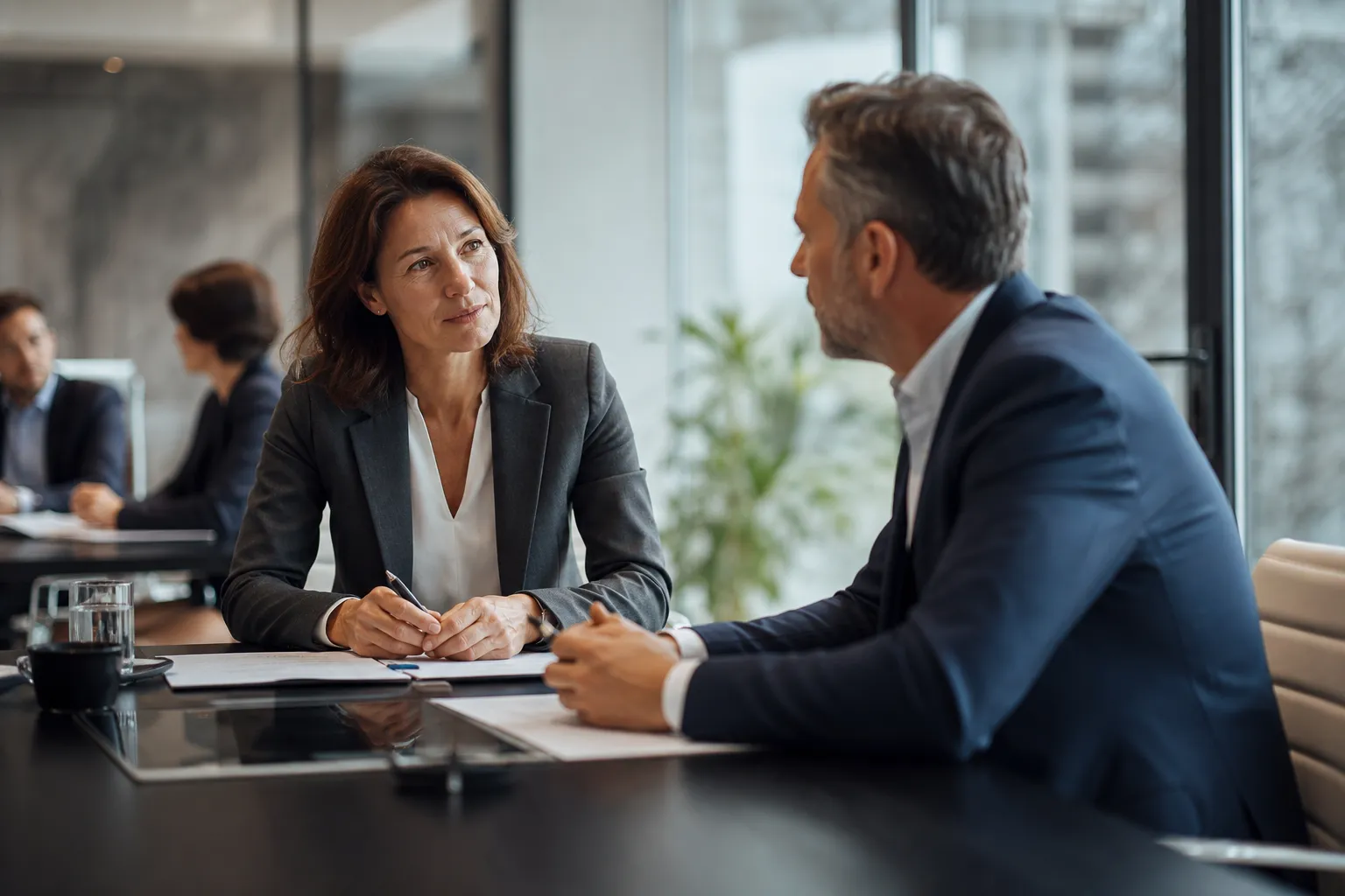 Réunion de négociation en entreprise autour d'une table, représentants du personnel et direction discutant de documents.