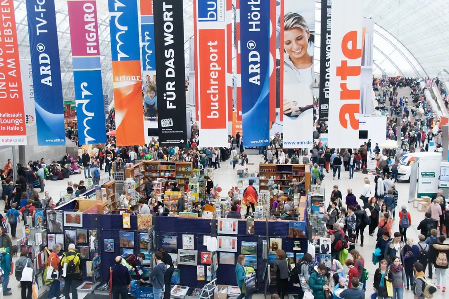 Une équipe échange avec des visiteurs sur un stand d’exposition professionnel équipé de supports visuels et d’un comptoir d’accueil.