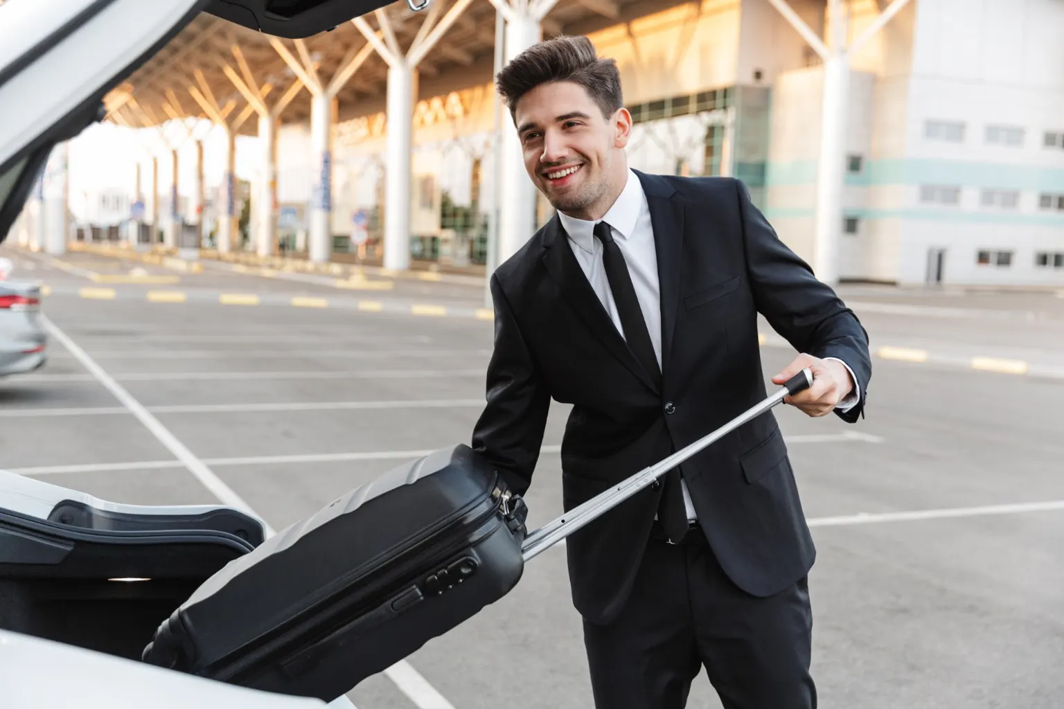 Un taxi attend devant le terminal de l’aéroport Marseille-Provence avec des voyageurs et leurs bagages.