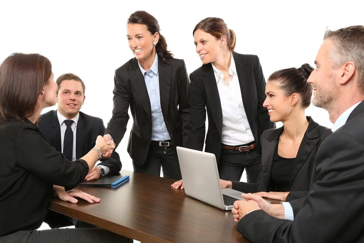 Une responsable d’entreprise échange avec un candidat et un consultant d’agence d’intérim autour d’un bureau.