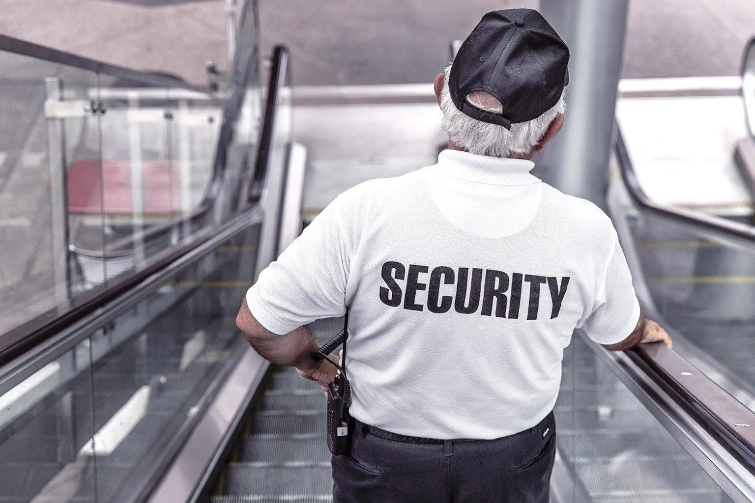 Un agent de sécurité contrôle l’accès à un site professionnel devant les locaux d’une entreprise.